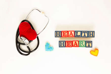 Heart health and prevention concept. Stethoscope and red heart of crochet on white isolated background with space for text.の写真素材
