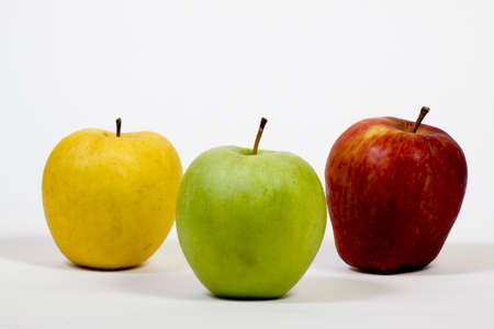Three apples of yellow, red and green colors placed next to each other on a white background.の写真素材
