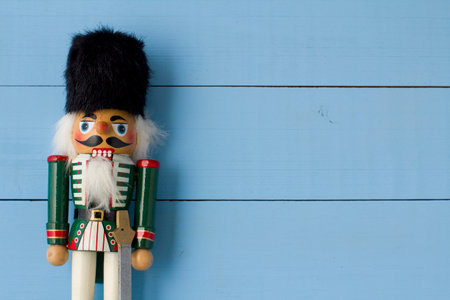 Interesting beautiful christmas nutcracker soldier on blue colored wooden surface texture with copy...