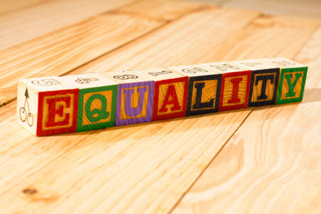 Spectacular wooden cubes with the word EQUALITY on a wooden surface.の写真素材