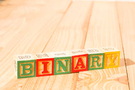 Spectacular wooden cubes with the word BINARY on a wooden surface.の写真素材