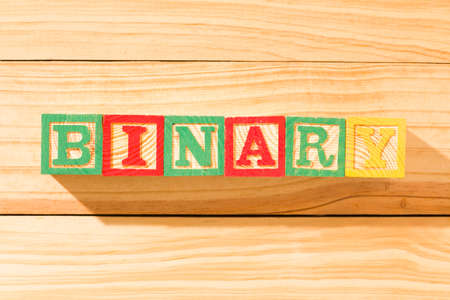 Spectacular wooden cubes with the word BINARY on a wooden surface.の写真素材
