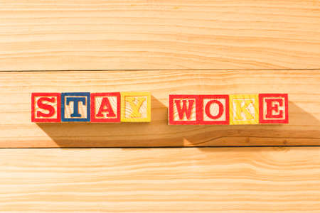 Spectacular wooden cubes with the word STAY WOKE on a wooden surface.の写真素材
