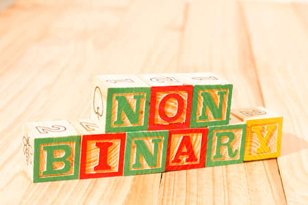 Spectacular wooden cubes with the word NON BINARY on a wooden surface.の写真素材