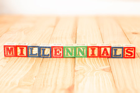 Spectacular wooden cubes with the word MILLENNIALS on a wooden surface.の写真素材