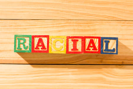 Spectacular wooden cubes with the word RACIAL on a wooden surface.の写真素材