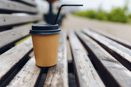 paper cup of coffee on wooden red benchの写真素材