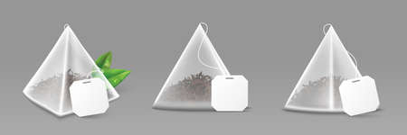 Isolated pyramid tea bags with empty white label in realistic 3d style. Transparent tea bag mockup with green leaves. Element for your design. Vector illustration.のイラスト素材