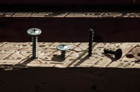 three screws screwed in the board one broken game of light and shadow 300dpiの写真素材