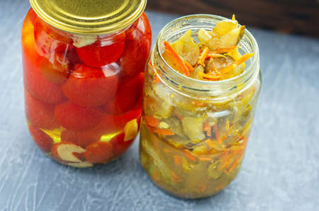 two jars of pickled fermented tomatoes and cucumbers. Bank of cucumbers open.の写真素材