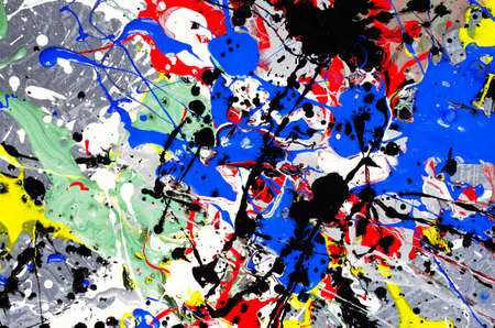a spot of white and black and yellow and green and red and blue spilled paint on a concrete textured...