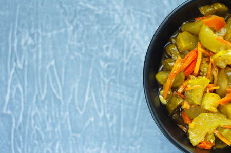 pickled fermented cucumbers and carrots in a dark salad bowl. Top View. Copy space in left.の写真素材