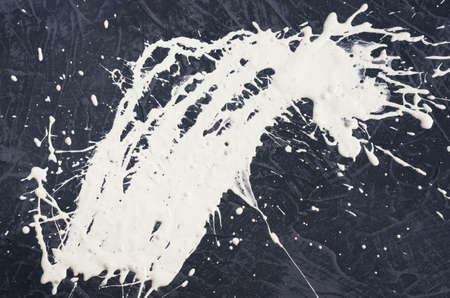 a spot of white spilled paint on a concrete textured surface.の写真素材