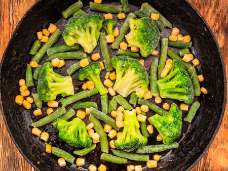 vegetables broccoli corn green beans in a cast iron skillet. View from above.の写真素材
