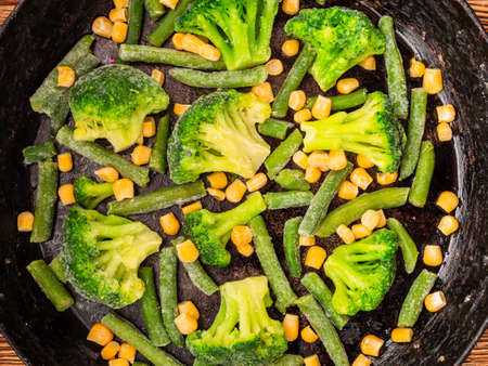 vegetables broccoli corn green beans in a cast iron skillet. View from above.の写真素材