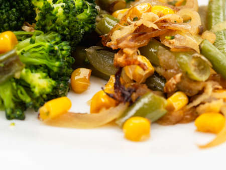 cooked vegetables broccoli, carrots, green beans, corn on a white plate. closeupの写真素材