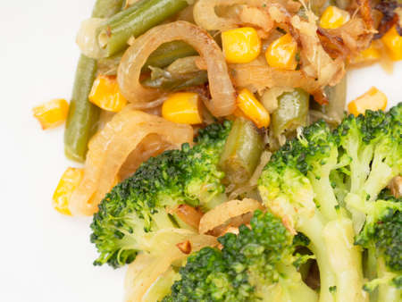 cooked vegetables broccoli, carrots, green beans, corn on a white plate. closeupの写真素材