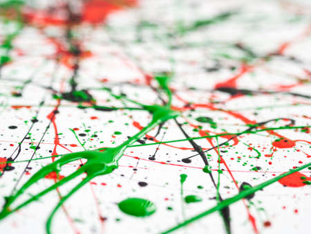 expressionism. red black green paint splattered with lines and drops on a white surface. Shallow...