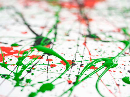 expressionism. red black green paint splattered with lines and drops on a white surface. Shallow depth of field.の写真素材