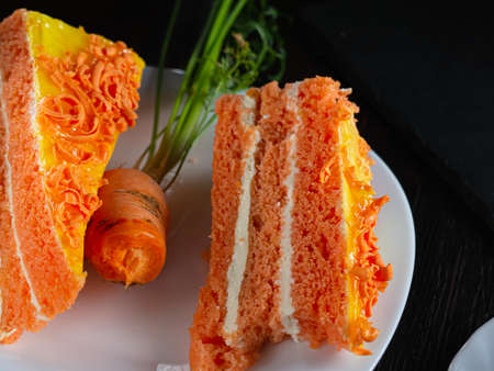 two bitten piece of carrot cake lies on a white plate. Inclined. Carrot is visible. Horizontal...