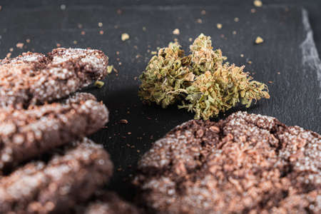 chocolate chip cookies with marijuana, sprinkled with chocolate chips and cannabis, are on a slate dish. Horizontal orientation.の写真素材