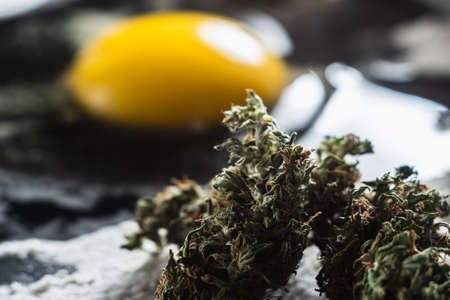 The process of making cannabis pastries. You can see a raw broken egg, a rolling pin, flour, and...