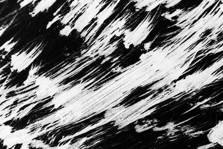 Patterns of white paint from a brush on a black background. horizontal orientation