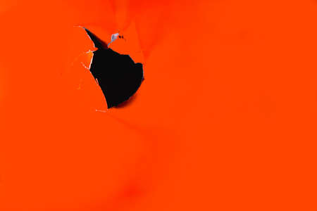 Torn gift in the surface of the color Lush Lava. Horizontal orientation.