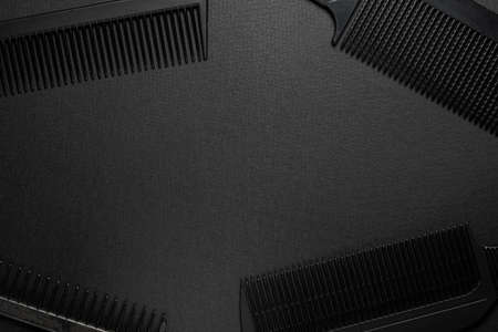 On a black surface are old barber tools. barber tools. four comb. black monochrome. frame. top view flate lay. frame copy spaceの写真素材