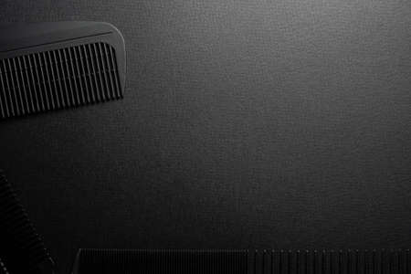 On a black surface are old hairdresser tools. combs. black monochrome. horizontal orientation. top view flat ley. copy spaceの写真素材