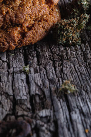 biscuits with marijuana on an old wooden background close-up. Healthy food with medical cannabis. the buds are inaccurately scattered. rustic. Vertical orientation.の写真素材