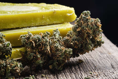 rustic cannabis butter and medical marijuana bud on old rust metal dripping pan. old wooden background. horizontal orientation. close-up.の写真素材