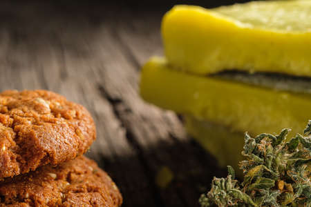 biscuits with marijuana and cannabis butter and bud on an old wooden background close-up. Healthy medical food with cannabis. the buds are inaccurately scattered. rustic. Horizontal.の写真素材