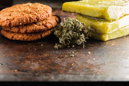 biscuits with marijuana and cannabis butter and bud on rust metal background close-up. Healthy medical food with cannabis. the buds are inaccurately scattered. rustic. Horizontal.の写真素材