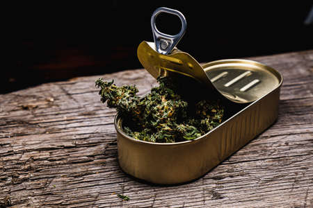 cannabis in a open tin can. on old wooden background. rustic. Horizontal orintationの写真素材