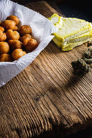 churros balls spanish donuts from medical cannabis butter, sugar, flour, egg. marijuana buds. medical cannabis butter. On a old wooden. vertical.の写真素材