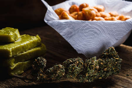 churros balls spanish donuts from medical cannabis butter, sugar, flour, egg. marijuana buds. medical cannabis butter. On a old wooden. horizontal.の写真素材