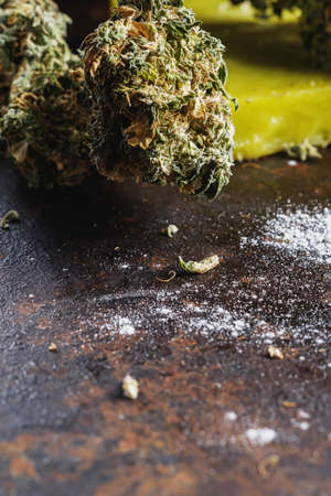 rustic cannabis butter and medical marijuana bud and flour on old rust metal dripping pan. old wooden background. vertical orientation. close-up.の写真素材