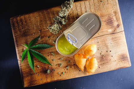 balls donuts from medical cannabis butter, sugar, flour, egg. marijuana buds. medical cannabis butter in a open tin can. hemp leaves. On a old wooden board. horizontal orientation. top viewの写真素材