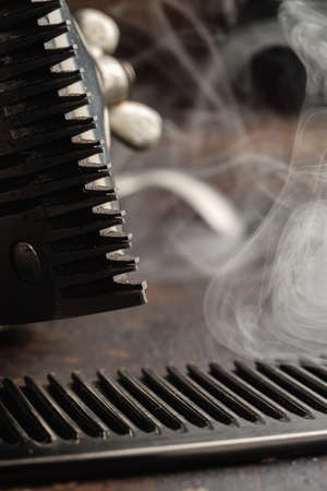 On a rusty surface manual clipper and comb. close up. rustic.vertical.の写真素材