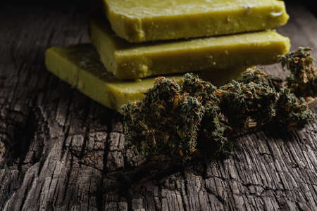 rustic cannabis butter and medical marijuana bud on old rust metal dripping pan. old wooden background. horizontal orientation. close-up.の写真素材