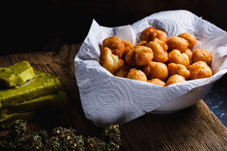 churros balls spanish donuts from medical cannabis butter, sugar, flour, egg. marijuana buds. medical cannabis butter. On a rusty baking sheet. horizontal orientation.の写真素材