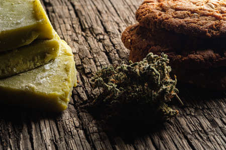 biscuits with marijuana and cannabis butter and bud on an old wooden background close-up. Healthy...