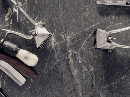 On a grey marble surface are old barber tools. top view. flat lay. copy space.の写真素材