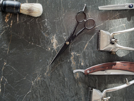 On a grey marble surface are old barber tools. top view. flat lay. copy space.の写真素材
