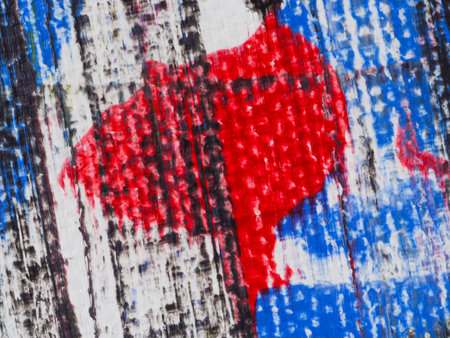 Vivid red and blue colors blend on a textured wooden surface, showcasing an abstract artwork that captures the viewer's attention with its dynamic patterns and colors.の写真素材