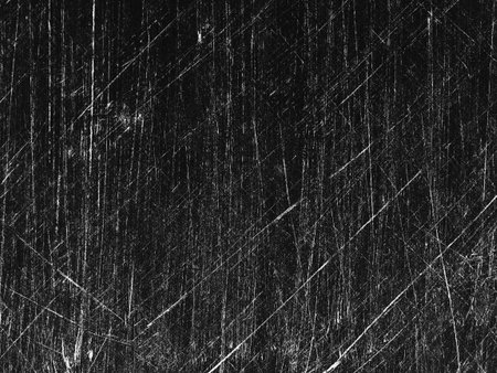 A textured dark surface covered with numerous white scratches forms an abstract design, evoking a sense of depth and dimension in the visual space.の写真素材