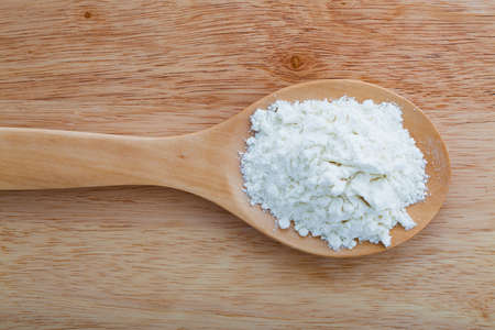 Wooden spoon with flour on a wooden tableの写真素材