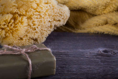 Soap, towel and a sponge on wooden boardの写真素材