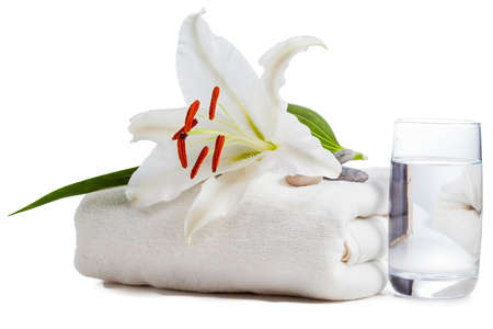 White lily on towel with glass of water isolatedの写真素材